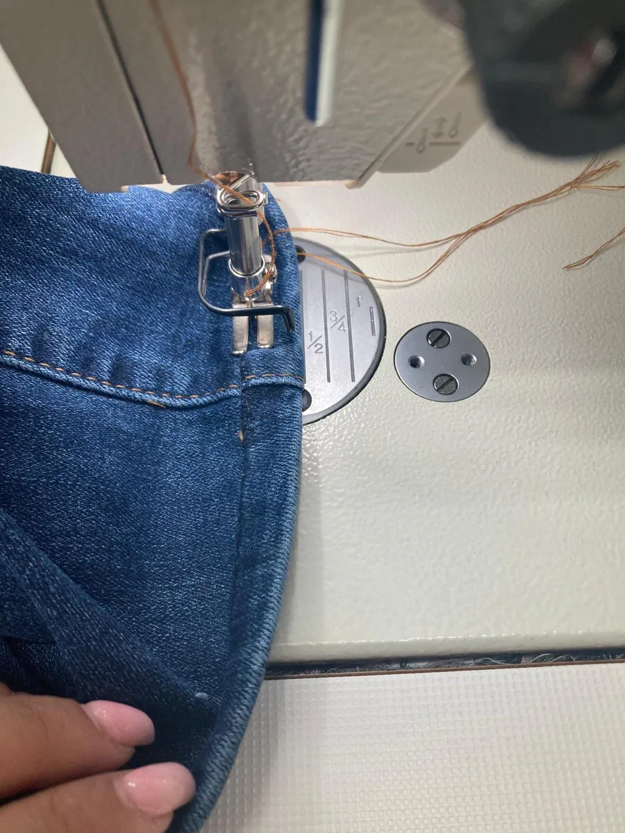 Jeans mit abgetrenntem Saum unter der Nähmaschine