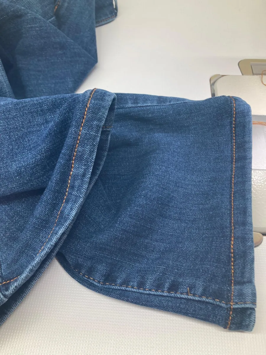 Fertiger Originalsaum einer Jeans mit orangefarbener Naht