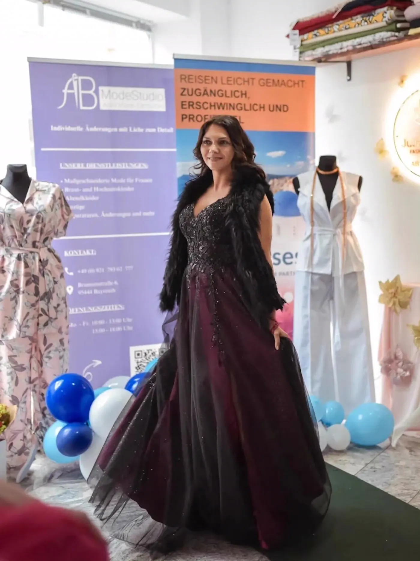 Model im schwarzen Abendkleid mit Glitzerdetails bei der Präsentation